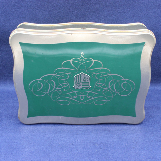 Decorative metal box with green top and silver design on a blue background