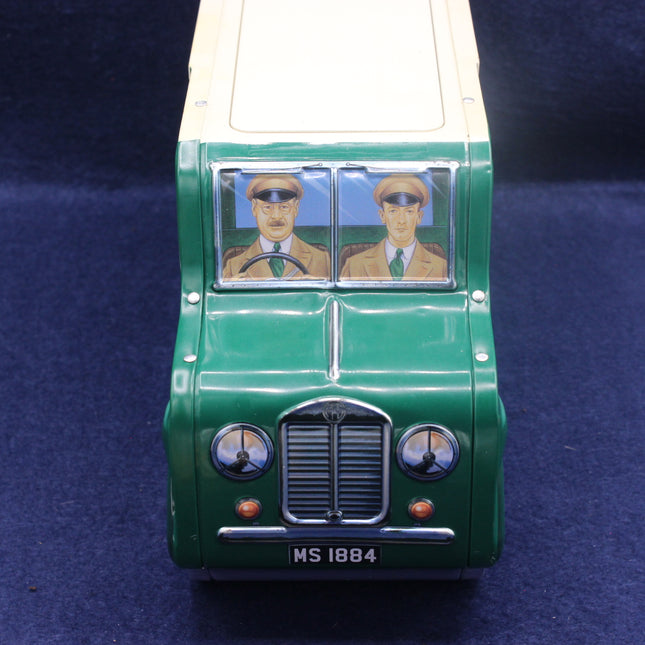 Model of a vintage green vehicle with portraits on the front window against a dark blue background