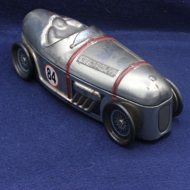 Vintage toy race car with number 84 on a blue background