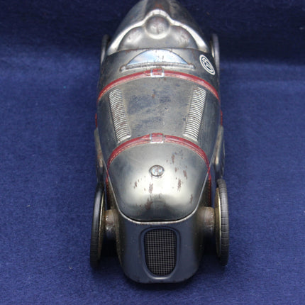 Vintage toy car with a metallic finish on a blue background