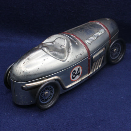 Vintage toy race car with number 84 on a blue background
