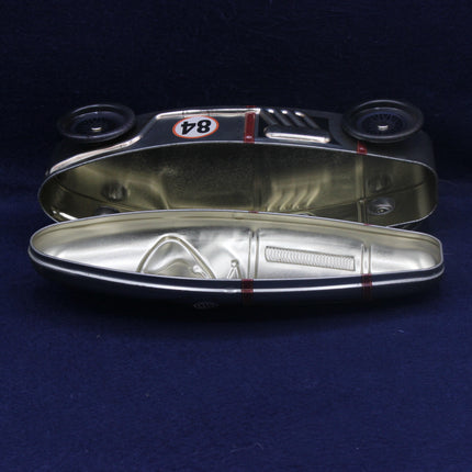 Metallic car headlight cover with '84' marking on a dark background