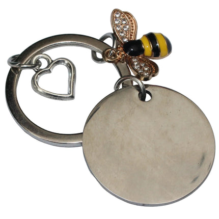 Keychain with bee charm and heart-shaped tag on a light gray background