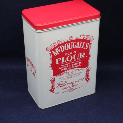 McDougalls Plain Flour tin with red lid on a dark background
