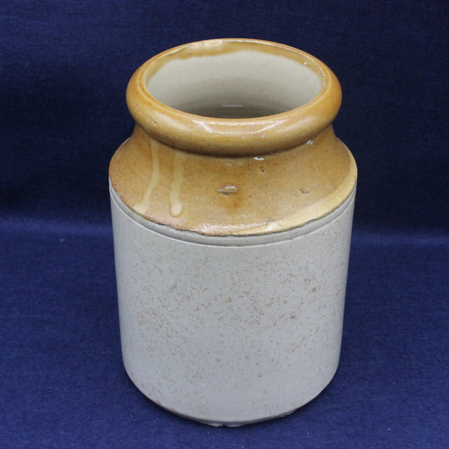 Ceramic jar with brown top and beige body on a blue background