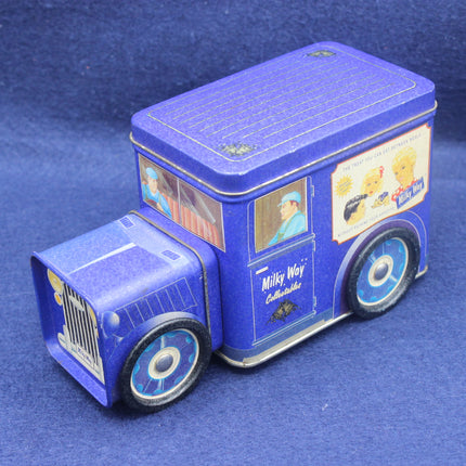 Blue toy truck-shaped tin with vintage design elements on a blue background