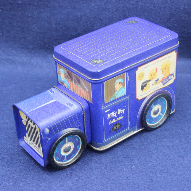 Blue toy truck-shaped tin with vintage design elements on a blue background