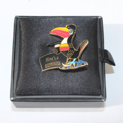 Colorful toucan pin with 'Mines a GUINNESS' text on a black box