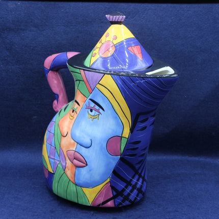 Colorful ceramic pitcher with artistic design on a blue background