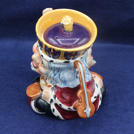 Decorative ceramic teapot with a purple candle inside on a blue background