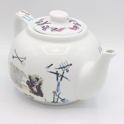 A white ceramic teapot decorated with whimsical, abstract hand-painted illustrations in blue, pink, and black, set against a seamless light gray background.
