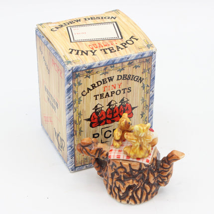 A miniature ceramic teapot by Cardew Design, styled like a brown textured bear, sitting in front of its branded wooden display box on a white background.