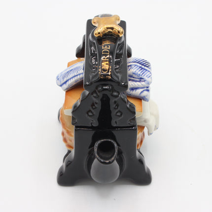 A ceramic teapot shaped like a horse-drawn carriage, featuring a glossy black body with gold lettering that reads 'CARDWELL', a blue and white striped fabric-like side detail, and a tan and white decorative section at the rear, photographed on a white background.