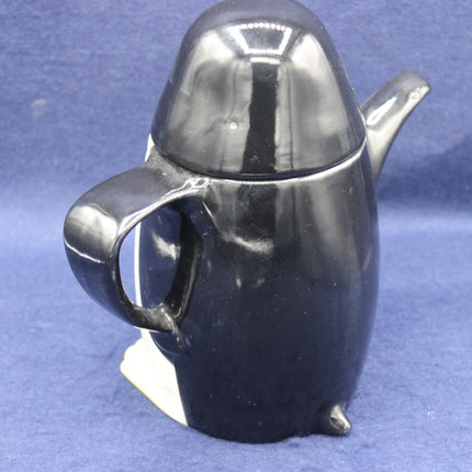 Black ceramic teapot on a blue background