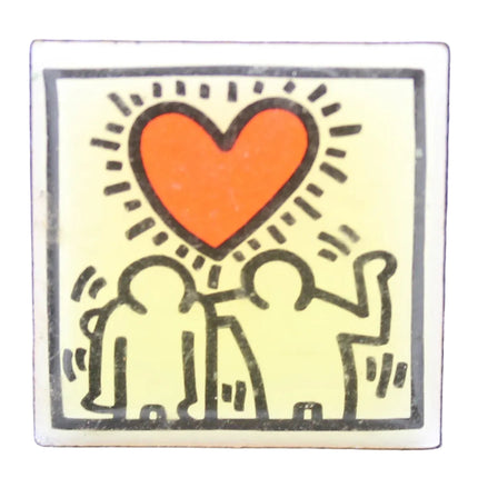 Small square sticker with two people holding a heart on a textured blue background