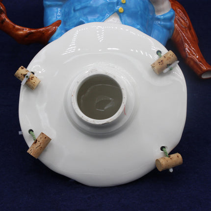 White ceramic object with cork stoppers on a dark background