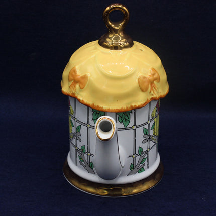 Decorative teapot with a yellow lid on a dark background