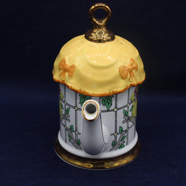 Decorative teapot with a yellow lid on a dark background