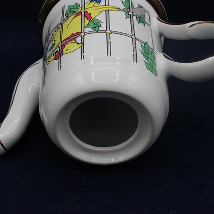 White teapot with colorful design on a dark background