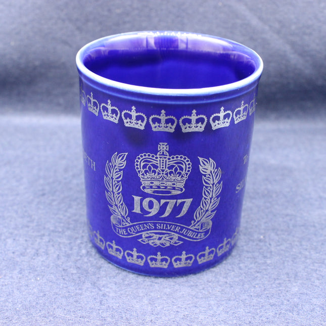 Blue mug with white crown and year design on a gray background