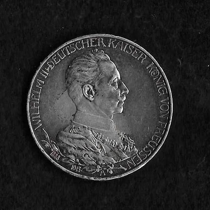 A silver-colored historical coin featuring a profile portrait of Kaiser Wilhelm II of Germany, inscribed with 'NILHEIM II DEUTSCHER KAISER KONG VON FREYSGAUEN', set against a dark textured background.