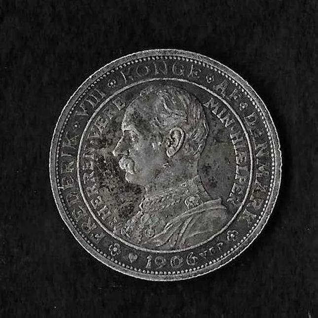 A round silver-colored coin featuring a profile portrait of King George V of the Netherlands, with Dutch text inscribed around the border, set against a dark textured background.