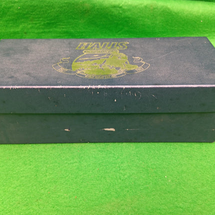 A dark charcoal gray textured shoe box with a gold foil 'HANDS' logo on the lid, resting on a bright green textured background.