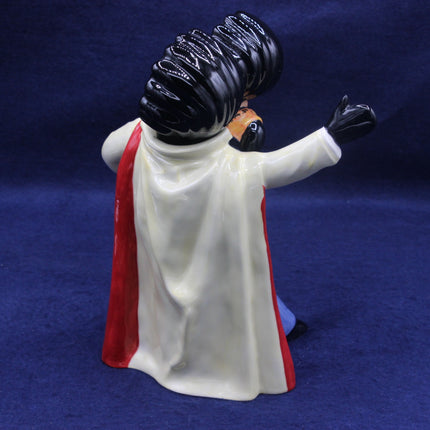 Figurine of a character with a red cape and black gloves on a blue background