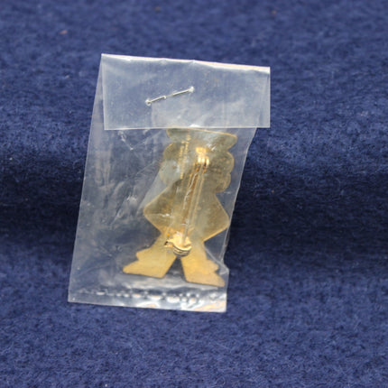 Gold-colored figurine in a clear plastic bag on a blue fabric background