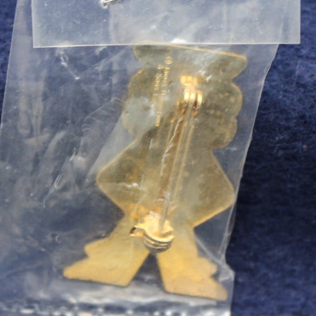 Gold-colored figurine in a clear plastic bag on a blue fabric background