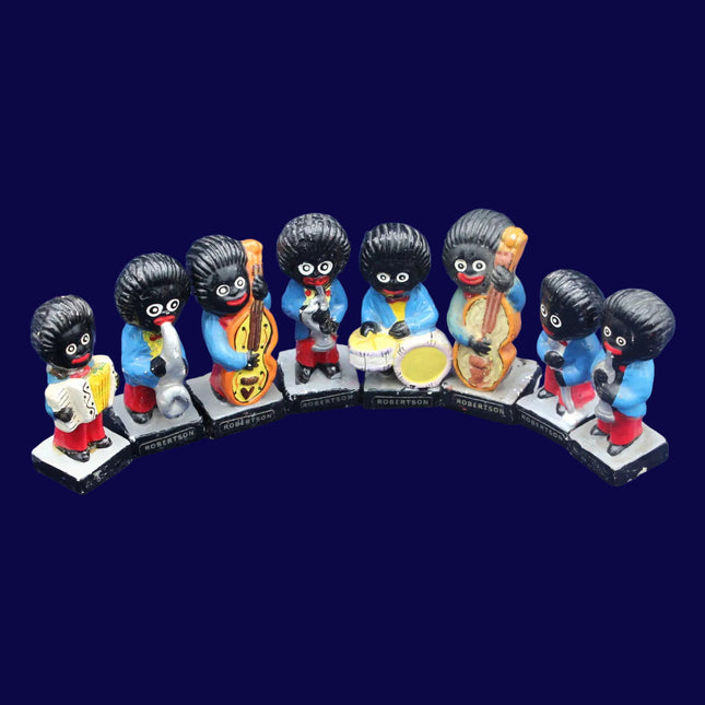 Set of eight small Golly figurines with black hair, colorful clothing, and musical instruments on a blue background.