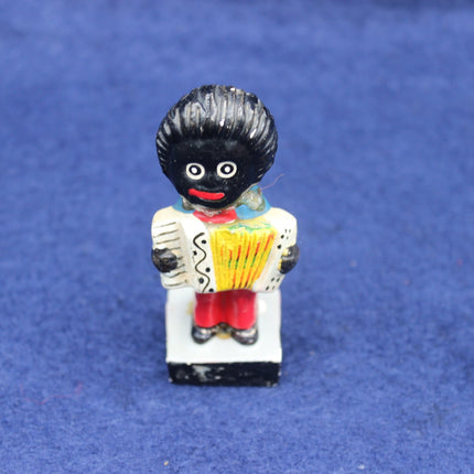 Small figurine of a Golly with a black hairstyle on a blue background
