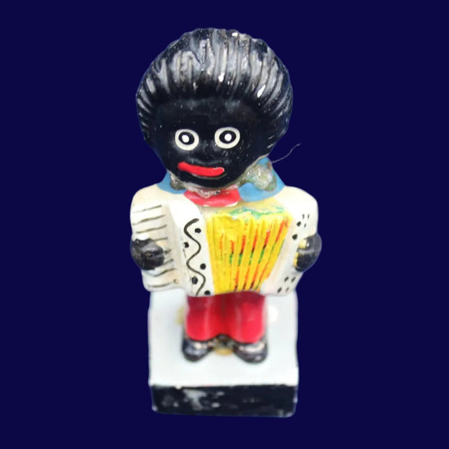 Small figurine of a Golly with a black hairstyle on a blue background