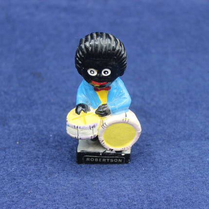 Figurine of a golliwog playing drums on a blue background