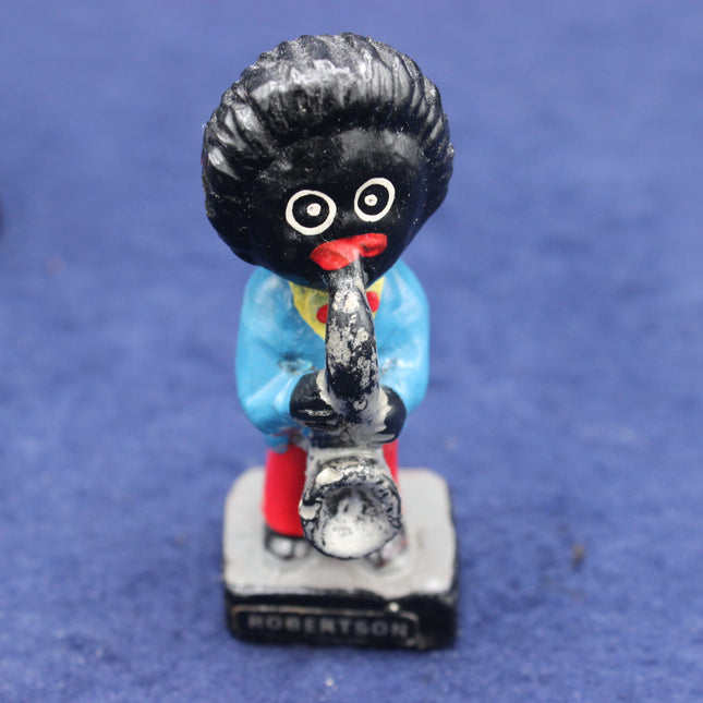 Vintage golliy figurine with a blue outfit and red shoes on a blue background