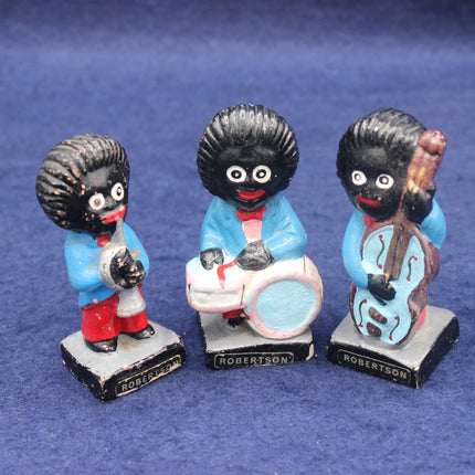 Three golly figurines with different poses on a blue background