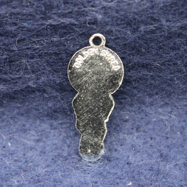 Silver Golly pendant on a textured blue background