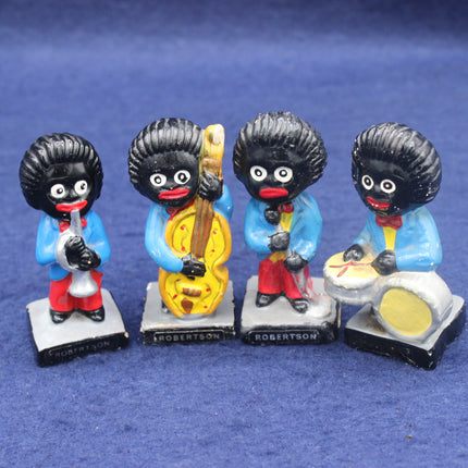 Four golly figurines playing musical instruments on a blue background