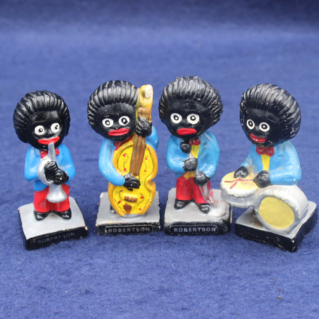 Four golly figurines playing musical instruments on a blue background