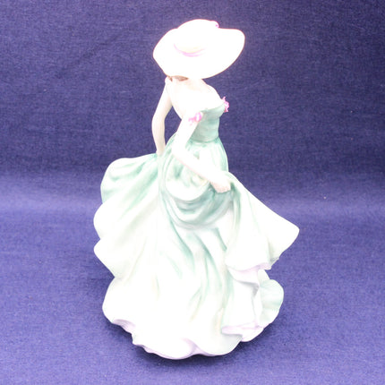 Porcelain figurine of a woman in a flowing dress on a purple background