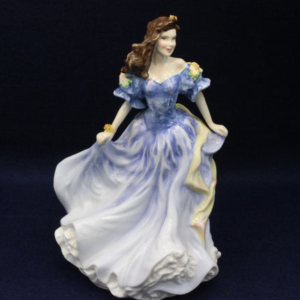 Porcelain figurine of a woman in a blue gown on a dark background