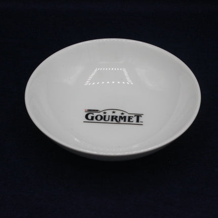 White plate with 'GOURMET' branding on a black background