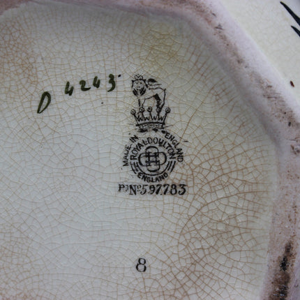 Close-up of a ceramic product with a brand logo and text on a cracked surface.