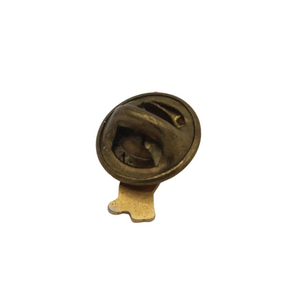 A small round vintage brass pin or button back with a gold-tone metal clasp and backing, shown on a plain light gray background.