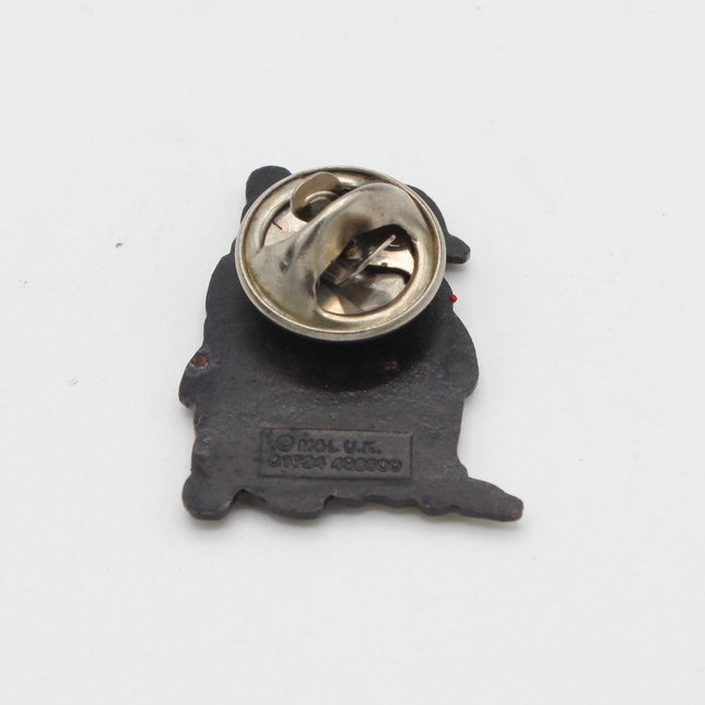 A small black enamel lapel pin shaped like a dog silhouette, showing the metal clutch backing with a silver-tone pin on a plain white background.