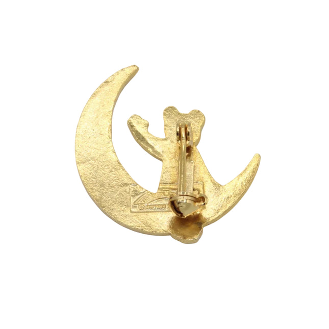 A small gold crescent moon and rupert bear pin shown from the back on a plain light gray background.