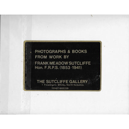 Plaque with text about photographs and books from Frank Meadow Sutcliffe, displayed on a white background.