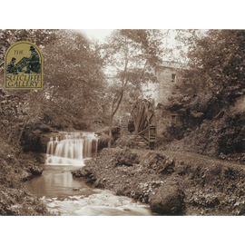 Black and white photograph of a watermill with a waterfall and surrounding trees.