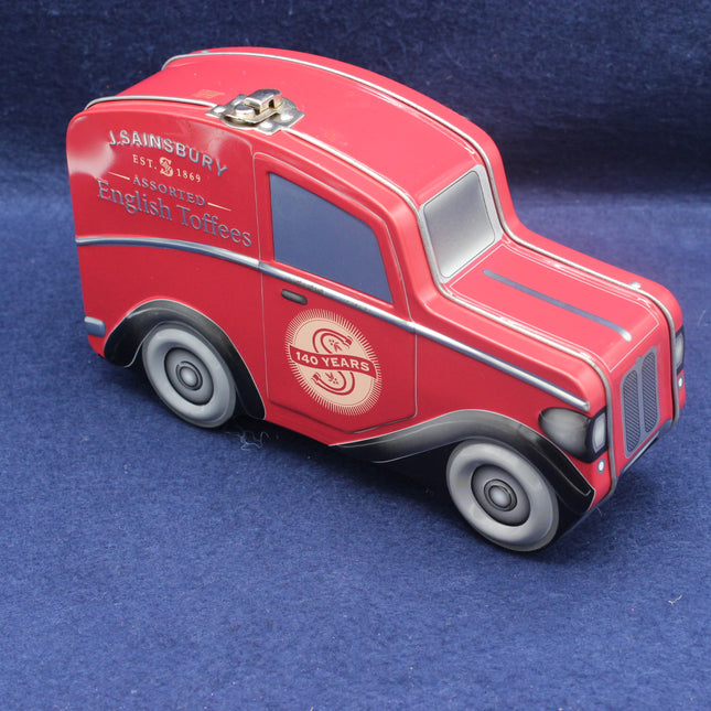Red truck-shaped tin with Sainsbury's branding on a blue background