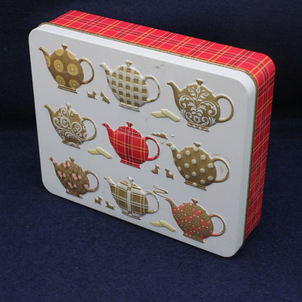 Biscuit tin with decorative tea pots on the lid
